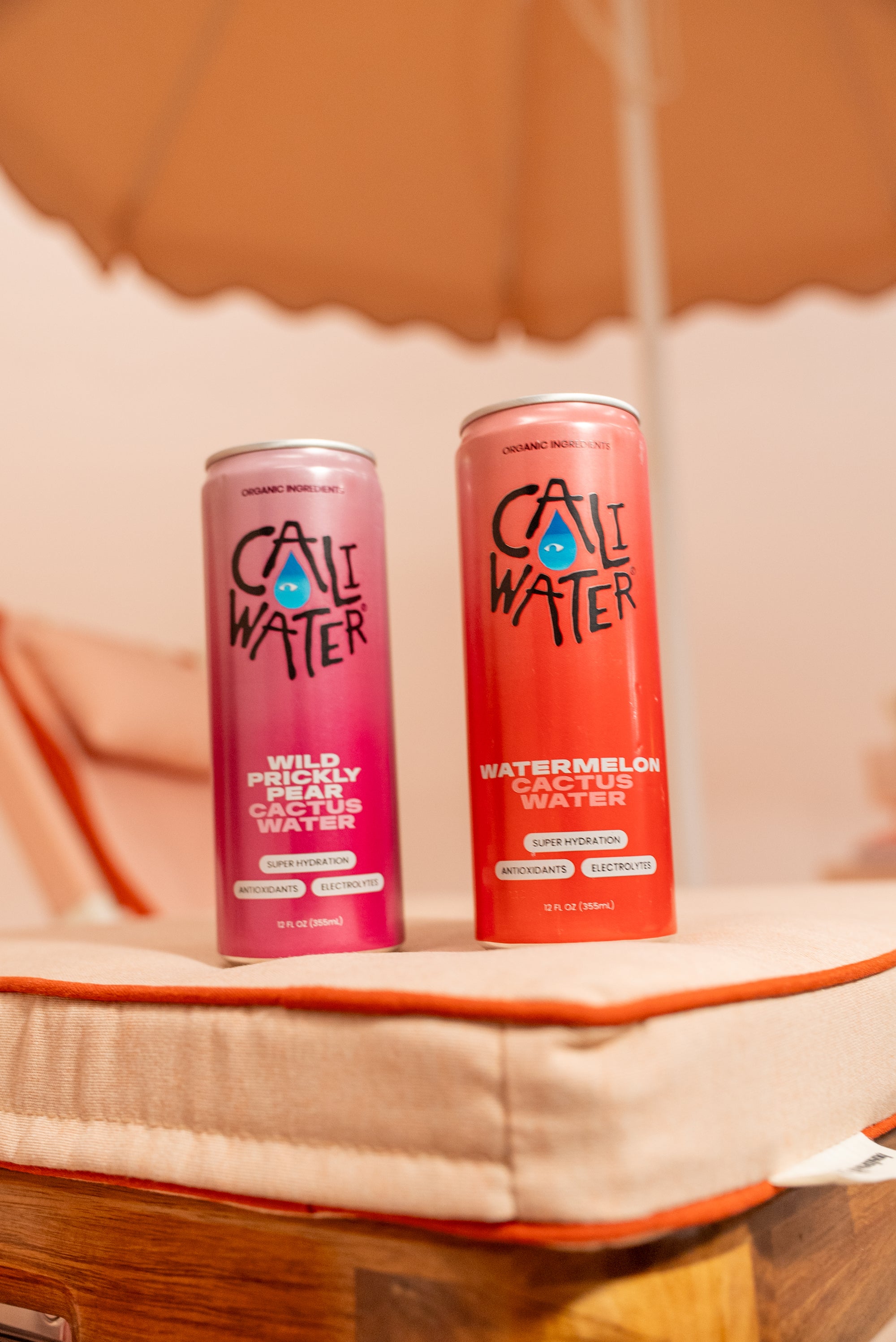 Caliwater cans on a sun lounger under an umbrella